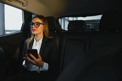 Some sort of interesting information. Smart businesswoman sits at backseat .. Stock Photos