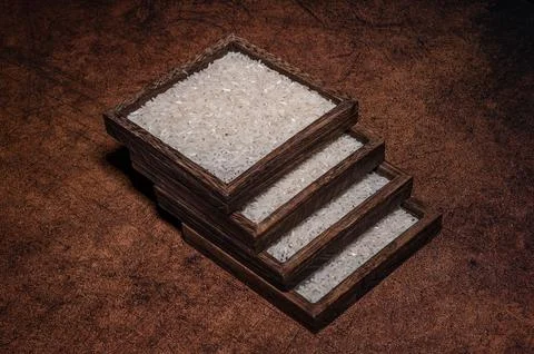 Some square containers of white rice in the dark background Stock Photos