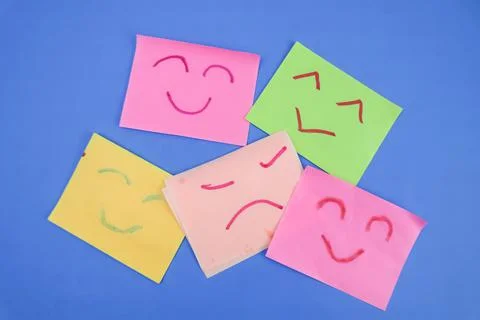 Some sticky notes with 5 expressions drawn with red and green markers on a bl Foto stock