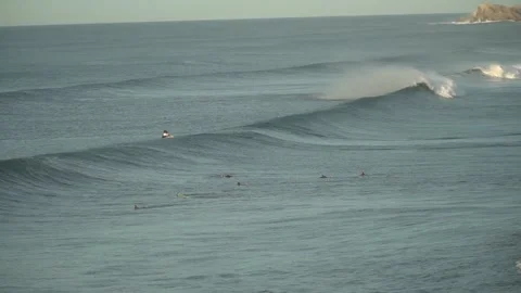 Some surfers surfing waves with the help of a jet ski Stock Footage 141867167