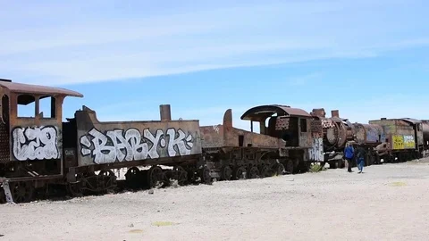 Some tourists are walking in the train cementery of Uyuni in Bolivia Video stock 82475921