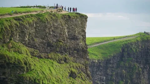 Some tourists on the edge of the Moher Cliffs in Ireland Stock Footage