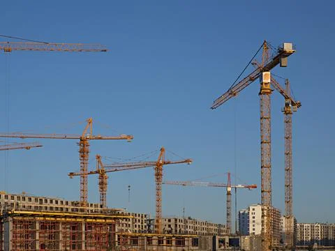 Some tower cranes on background of blue sky Stock Photos