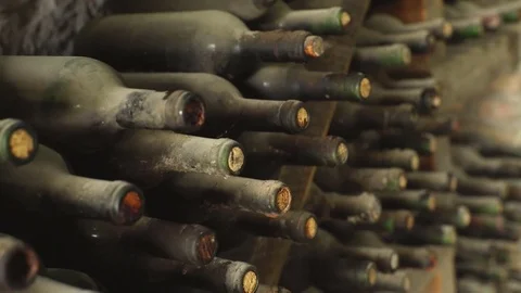 Some very old and dusty wine bottles in a wine cellar Stock Footage 76325409
