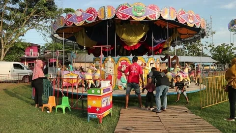 Some visitors who are riding the merry-go-round in the city park Stock Footage 239246259
