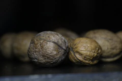 Some walnuts with shell in black background Stock Photos