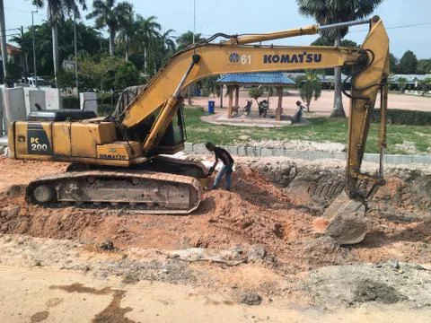 Some workers are looking at excavators Stock Photos
