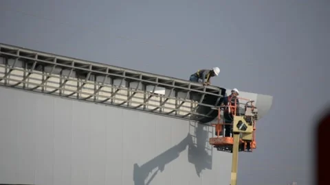 Some workers on siding works look from distance 스톡 동영상 212526219