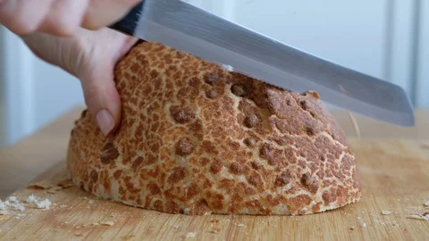 Somebody cutting freshly baked soft bread, close up Stockbeeldmateriaal 129486273
