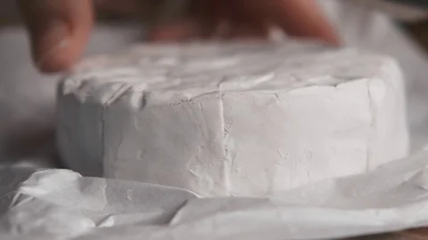 Somebody cutting soft cheese (camembert or brie) . Macro shot 動画素材 120026328