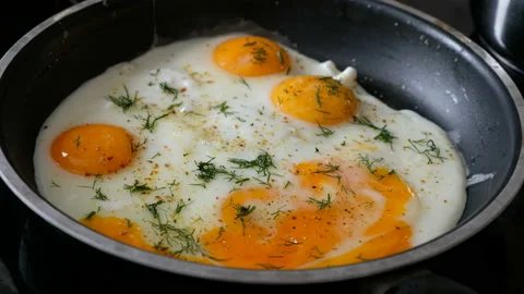 Somebody frying eggs on a pan, close up Vídeos de archivo 103996917