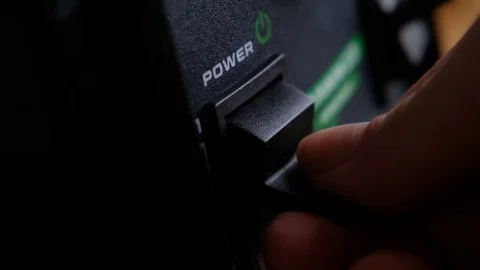 Somebody turn switch on the power button on an electrical device Stock Footage 125990194