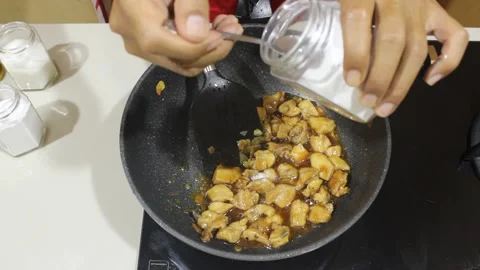 Someone adds various spices to the dish. add salt. add sugar. add flavoring  Stock Footage 333777707