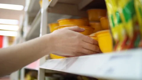 Someone chooses containers with noodles or instant soup in a supermarket Stock Footage 90482629