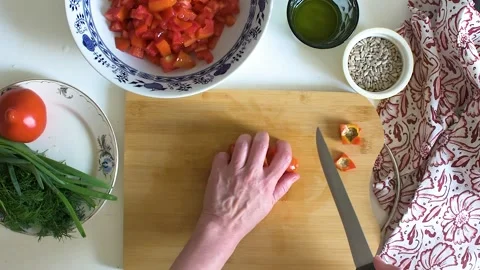 Someone chops fresh tomatoes and mixes them in a bowl with herbs and other .. Stock-Footage 337720268