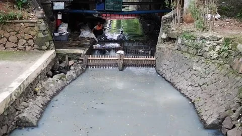 Someone cleans the river that is polluted under the bridge Video stock 302326629