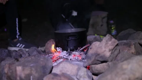 Someone cooking over a fire Stock Footage 167978986
