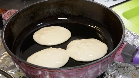 Someone cooking pancakes at a kitchen  Видео 102202605