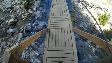 Someone crosses canopy bridge across the river POV Stock Footage 119512259