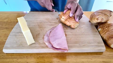Someone Cutting Croissant preparing ham and cheese croissant Stock Footage 327235601