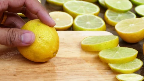 Someone cutting a lemon on the chopping board Stock Footage 77757038