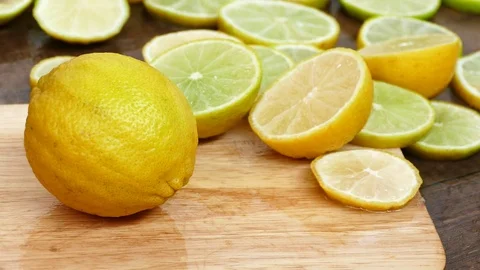 Someone cutting a lemon on the chopping board Stock Footage 77758737
