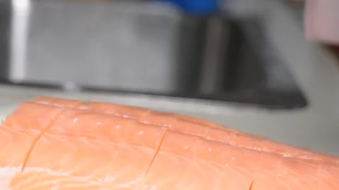 Someone is cutting salmon fillets.  close-up on hands, selective focus. Vidéo 150704033