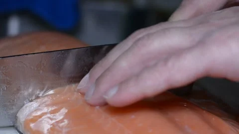 Someone is cutting salmon fillets.  close-up on hands, selective focus. Vidéo 150704351
