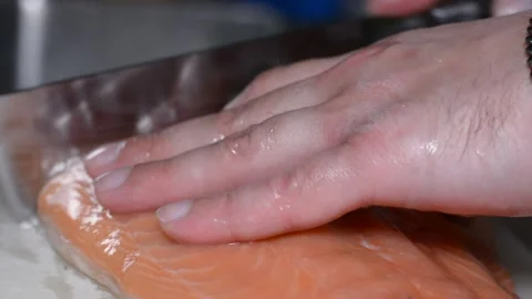 Someone is cutting salmon fillets.  close-up on hands, selective focus. Vidéo 150704354