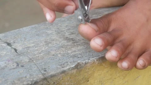 Someone is cutting toenails using a metal nail clipper Stock Footage 333342850