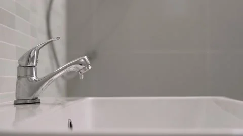 Someone does not close the faucet completely, causing water to drip all the t Stock Footage 164673541