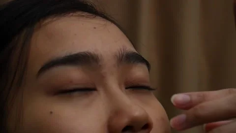 Someone dripping eye drops on asian woman's eyes. Eye diseases and their treatme Stock Footage 199698643