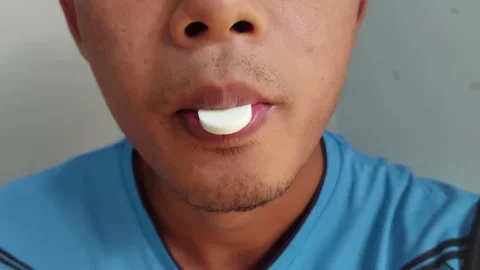 Someone eating a round white mint candy Video stock 242559544