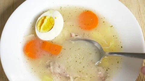 Someone eats chicken soup with egg from a plate. 4k, slow motion Stock Footage 83604193