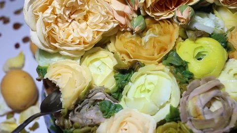 Someone eats an edible flower from a cake. Baked goods are decorated with imitat Stock Footage 143675619