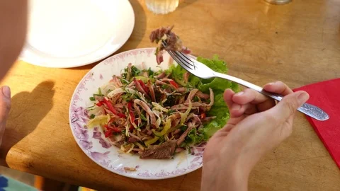 Someone eats meat salad with a fork and a knife. close-up. Slow motion. Stock Footage 77653167