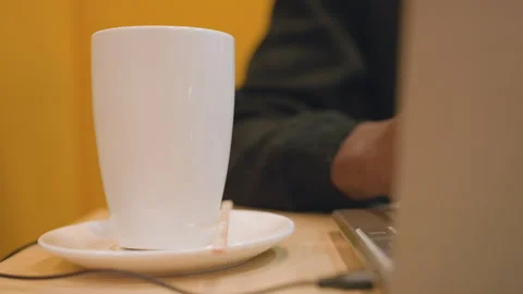 Someone focused on typing at cafe table during warmth of setting. An individual Stock Footage 338285089