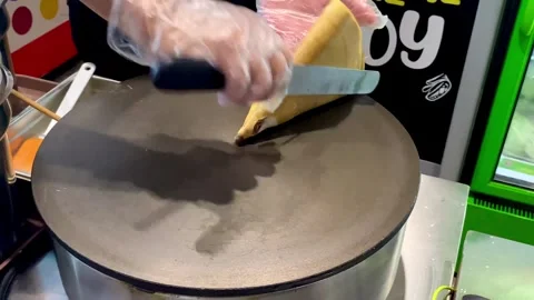 Someone is folding the crepe batter that is cooked and ready to be served Stock Footage 293646402