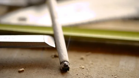 Someone forget a burning cigarette on oak workbench in carpenters workshop Stock Footage 114379238