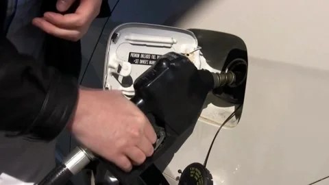 Someone hand holding nozzle for refueling car from gas station or petrol Stock Footage 336569592