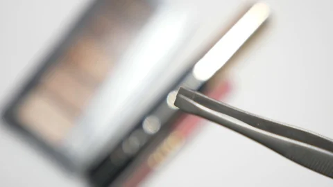 Someone is holding tweezers to pull out eyebrows against the background of a Video stock 90491002