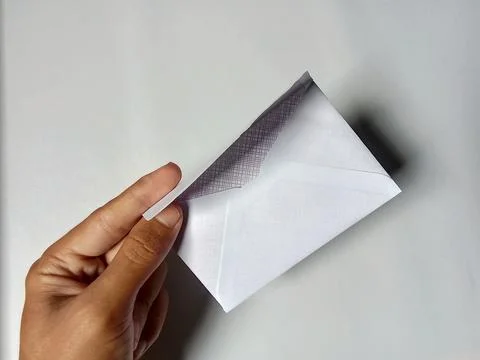 Someone holding a white envelope, in the background. Фото