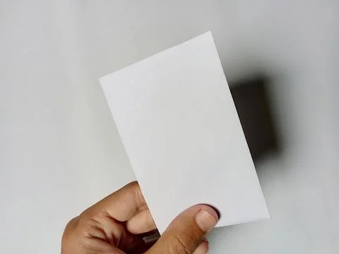 Someone holding a white envelope, in the background. Фото