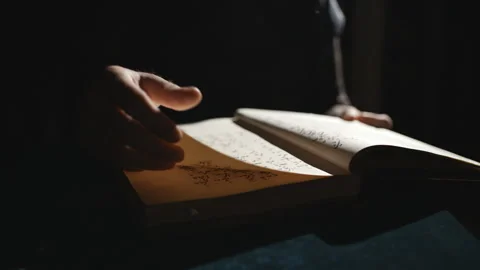 Someone is leafing through old book in dark Stock-Footage 99079106
