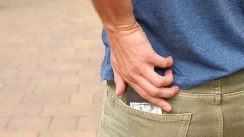 Someone loses 100 Dollars from their pockets, which falls on the sidewalk in the Stock Footage 79595377
