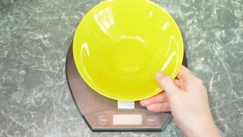 Someone measures the bran in electronic form in the kitchen. 4k, Stock Footage 83008496