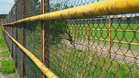 Someone is moving forward along the iron mesh fence, the subjective camera Stock Footage 93309484