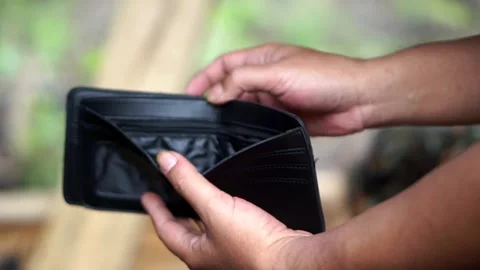 Someone opening an empty black leather wallet containing no cash Stock Footage 345476557