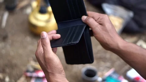 Someone opening an empty black leather wallet containing no cash Stock Footage 345477145
