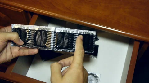 Someone opens a box of condoms inside, counts them and takes three Видео 66002977